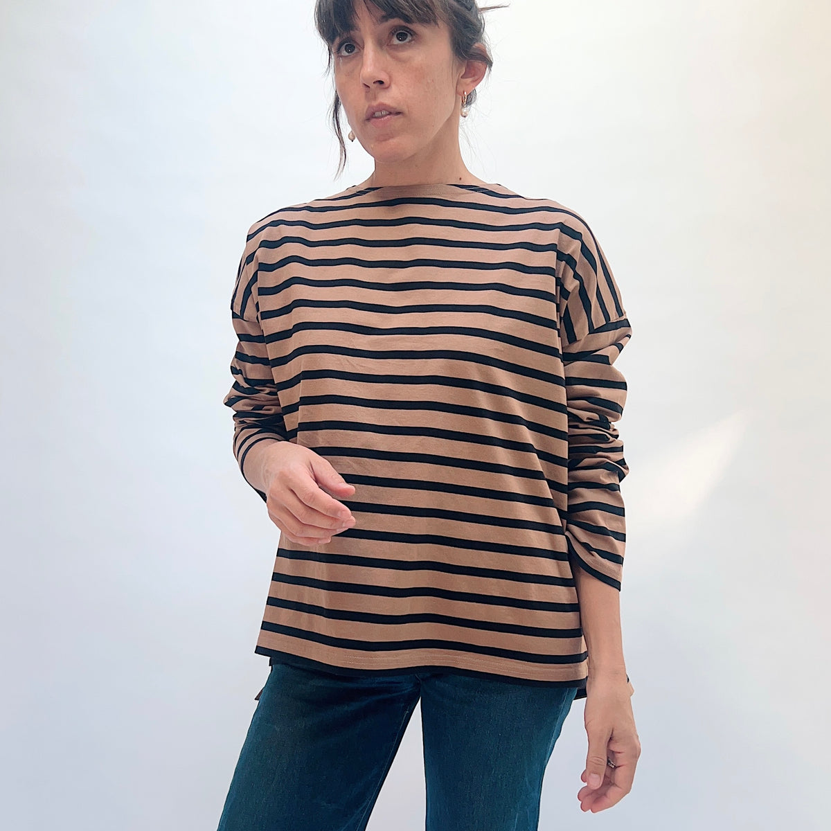 Front view of the mocha and navy striped knit pullover, showing the wide neckline and sleeves pushed up.
