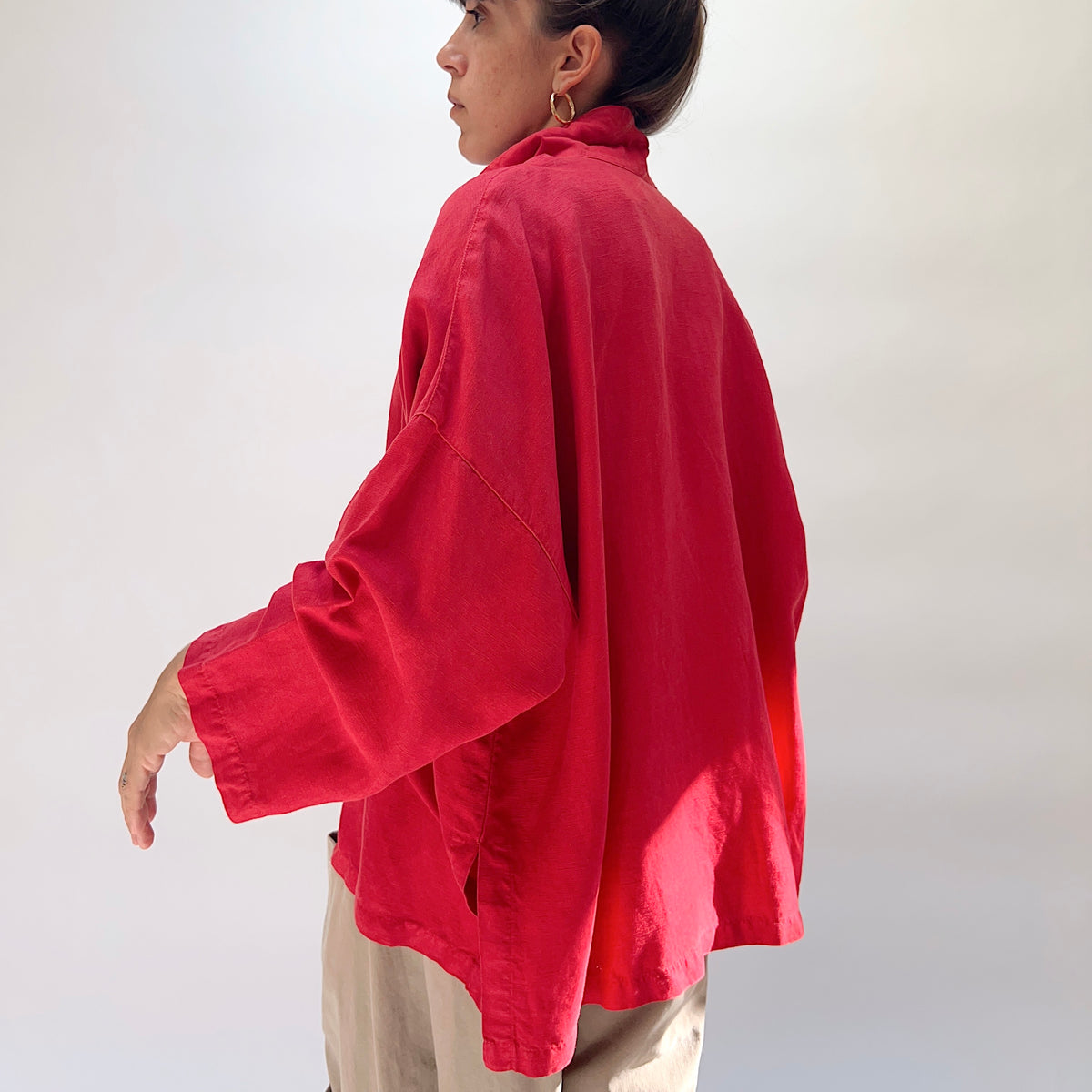 Eleven Stitch Linen Blend Big Shirt in Cayenne, back view on model, showing wide back panel, yoke seam detail, wide sleeves with cuffs, and curved hem with side slits, paired with khaki wide-leg trousers
