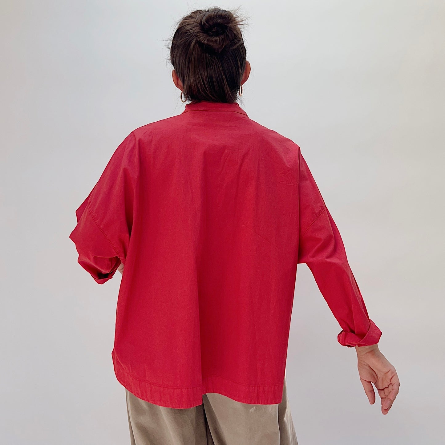Eleven Stitch Stand Collar Jacket in Cayenne, back view on model, showing clean back panel and curved hem, paired with khaki wide-leg trousers
