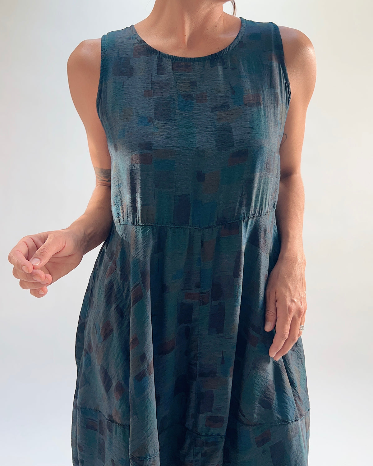 Close-up detail of the Cut Loose Sea Glass Seamed Parachute Bubble Dress in Etan showing the elasticated waist seam and abstract brushstroke block print in deep teal and warm brown viscose-nylon
