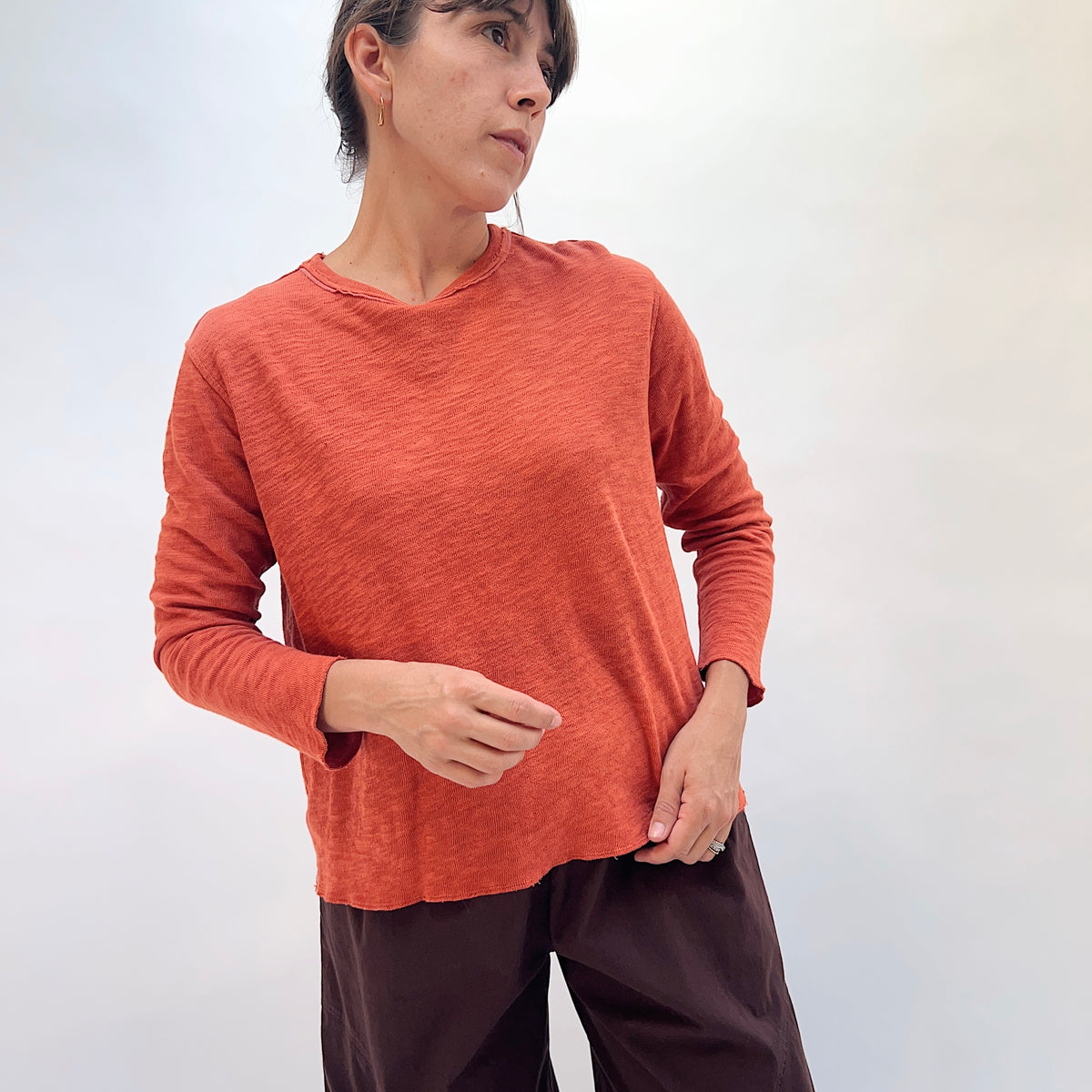 North Star Base Double Cotton Tee in Rusty, front three-quarter view showing the relaxed fit and raw-edge hem in rusty orange
