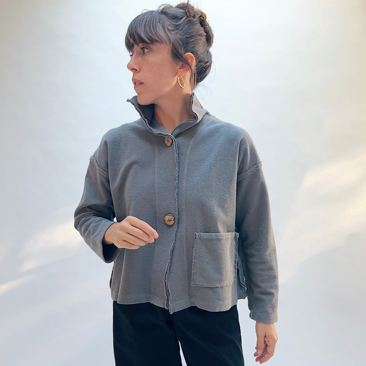 Eleven Stitch Funnel Jacket in Eiffel Tower, front three-quarter view showing the funnel neck, button-front closure, and front patch pocket in slate blue-gray cotton terry
