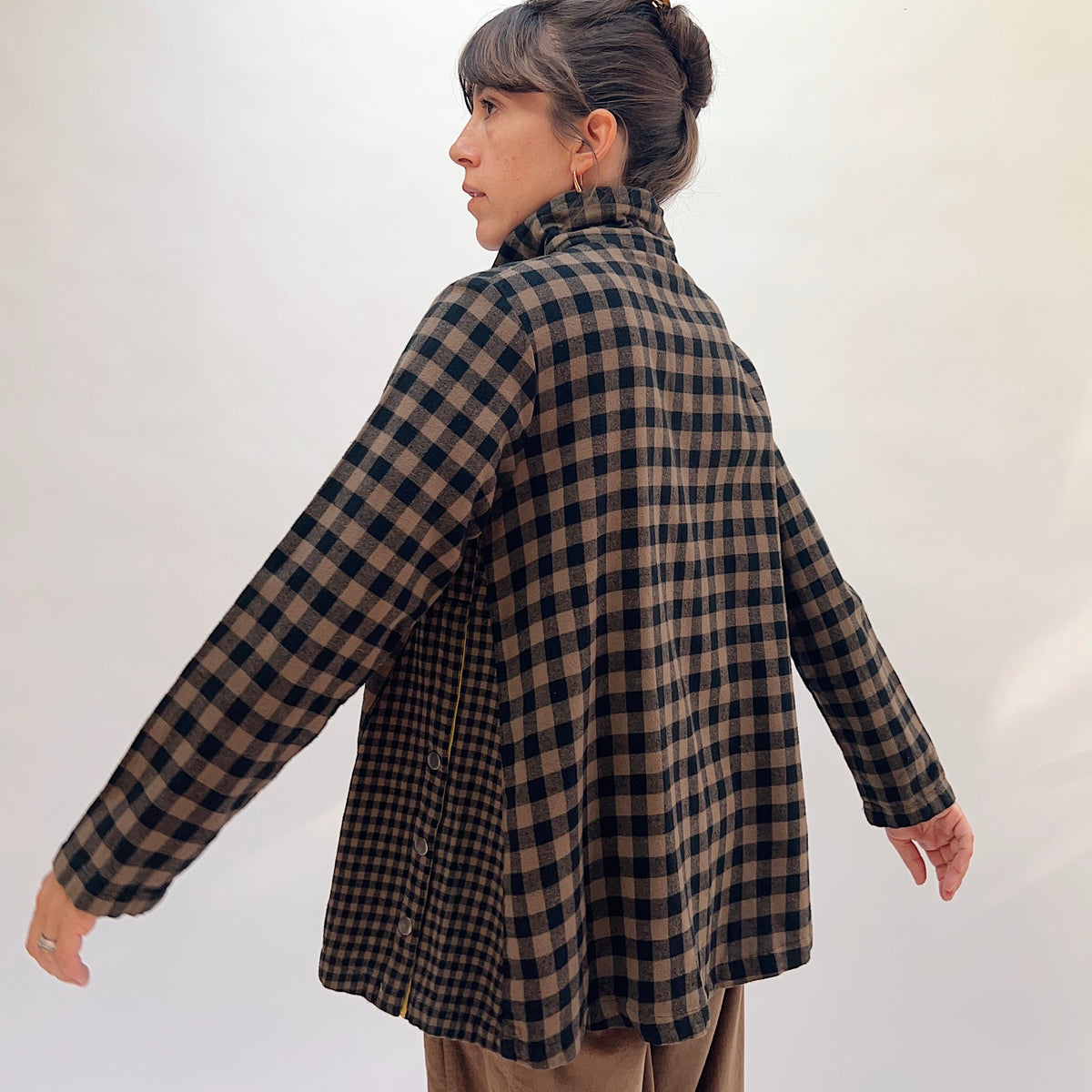 Eleven Stitch Placket Gusset Shirt in Winter Olive, three-quarter back view showing the oversized silhouette, back yoke, and side gusset vents in brown and black gingham check cotton
