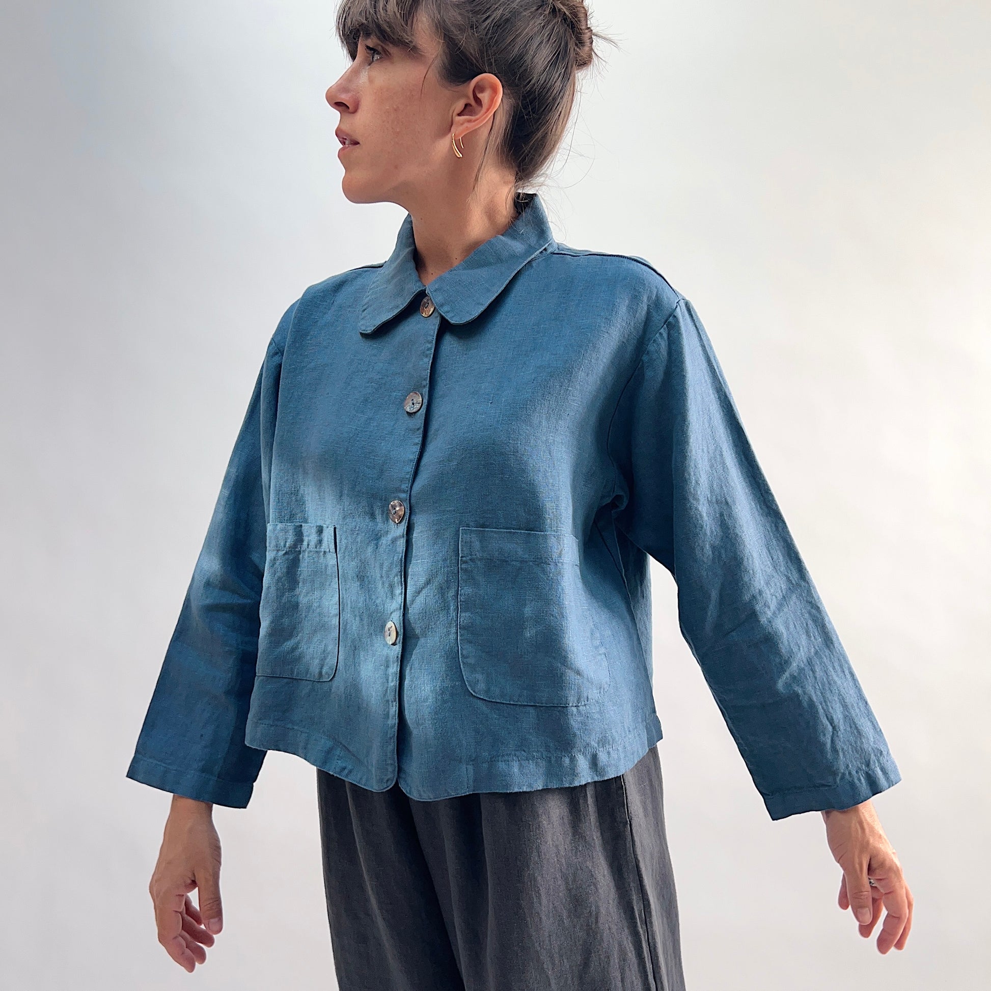 Three-quarter side view of the Bryn Walker Heavy Linen Audrey Jacket in Vitznau, highlighting rounded collar, shell buttons, patch pockets, and linen texture
