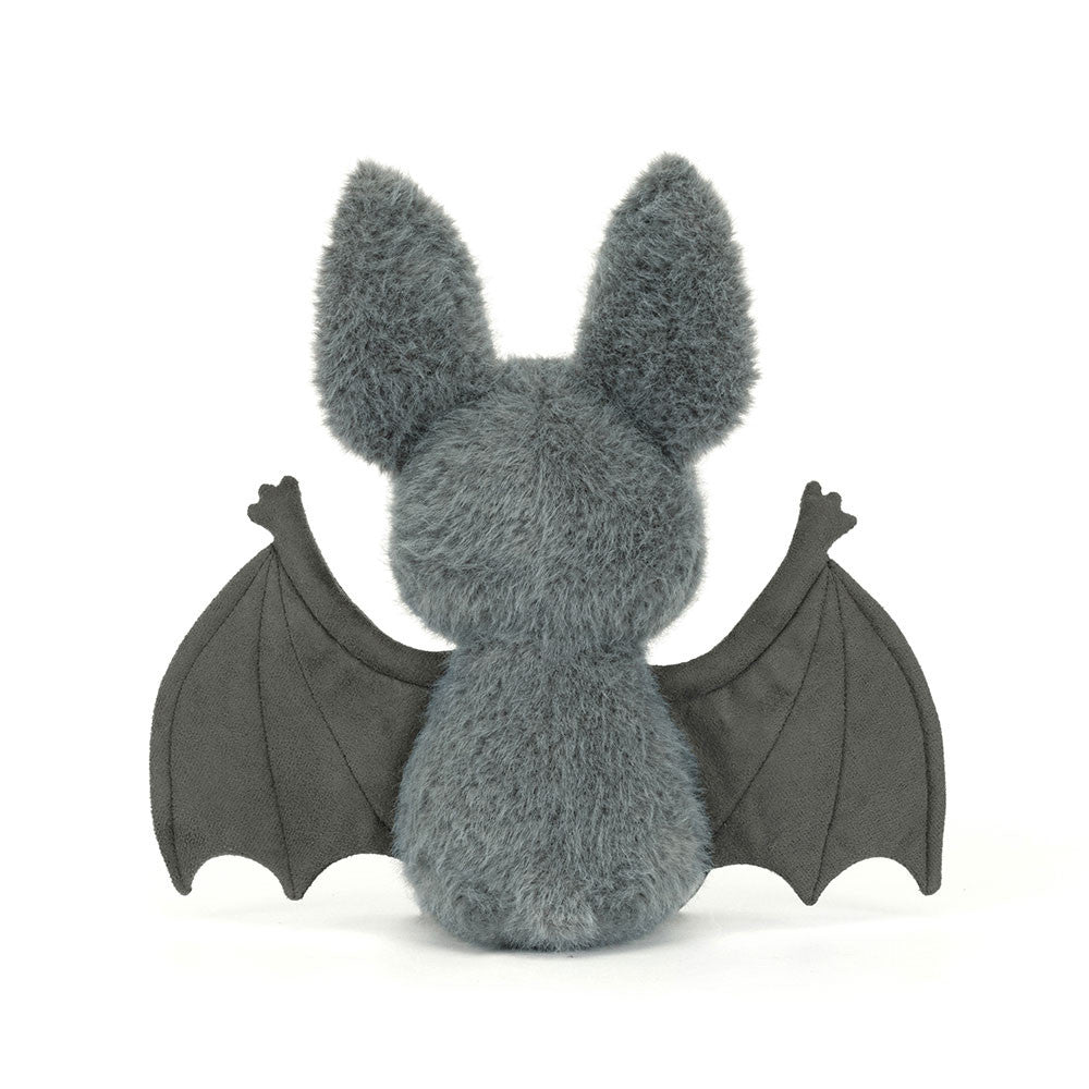 Rear view of the Jellycat Broox Bat plush toy on a white background, showing the blue-grey fluffy back, two large ears, and both dark wings spread wide