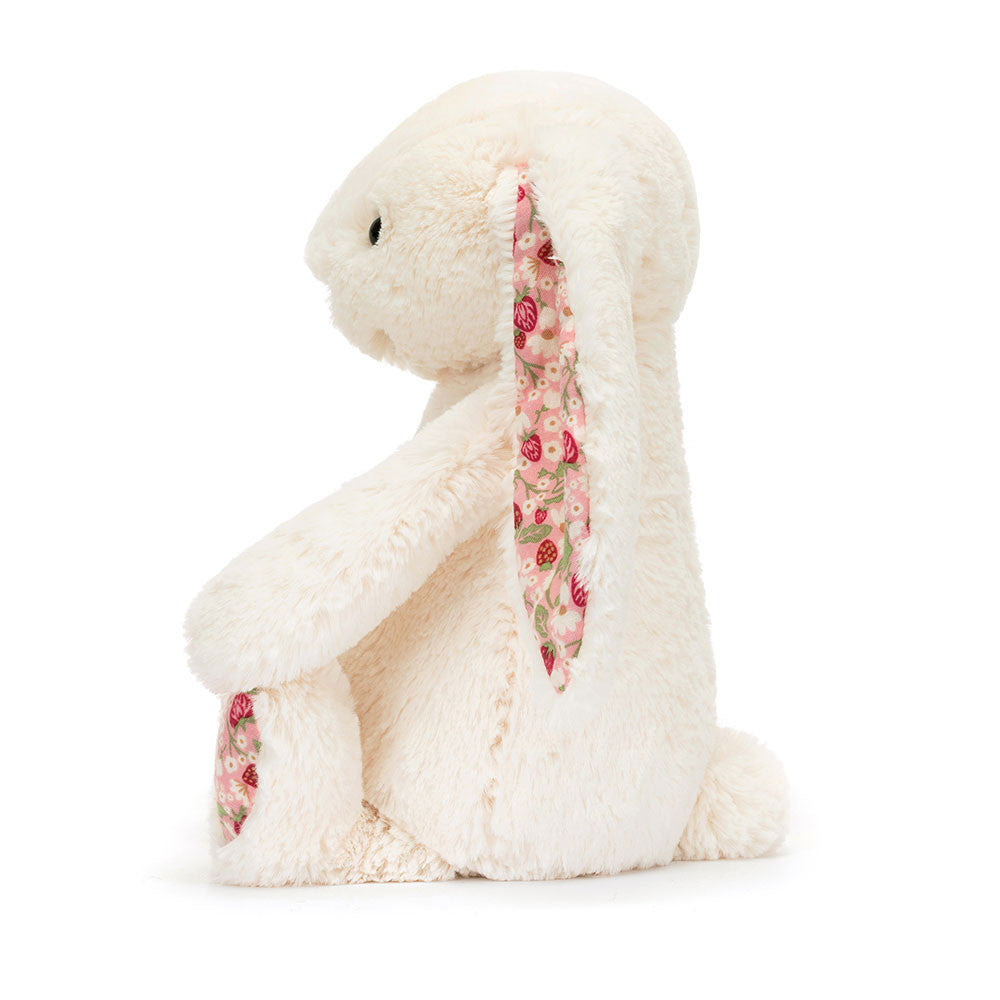 Jellycat Blossom Cream Bunny 'Berry' Original — side profile view showing the long floppy ear with pink strawberry floral lining, cream textured fur, and strawberry print paw pad, on a white background
