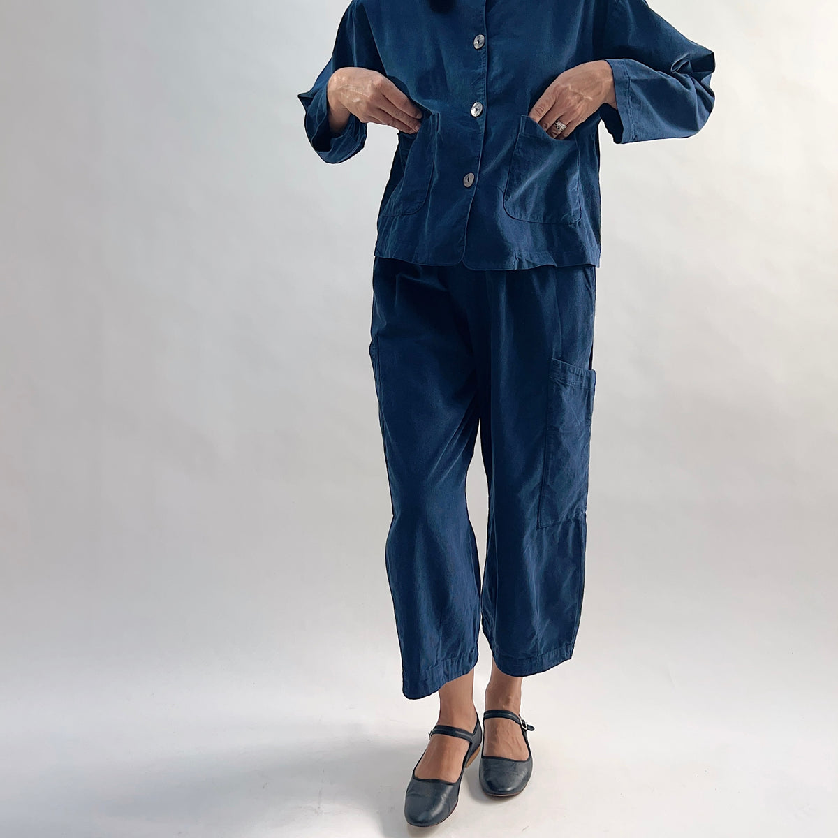 Model wearing the Bryn Walker Corduroy Pasha Pants in Nova paired with the matching Audrey Jacket, front view showing elastic waistband, hip pockets, and navy pinwheel corduroy, with black Mary Jane flats
