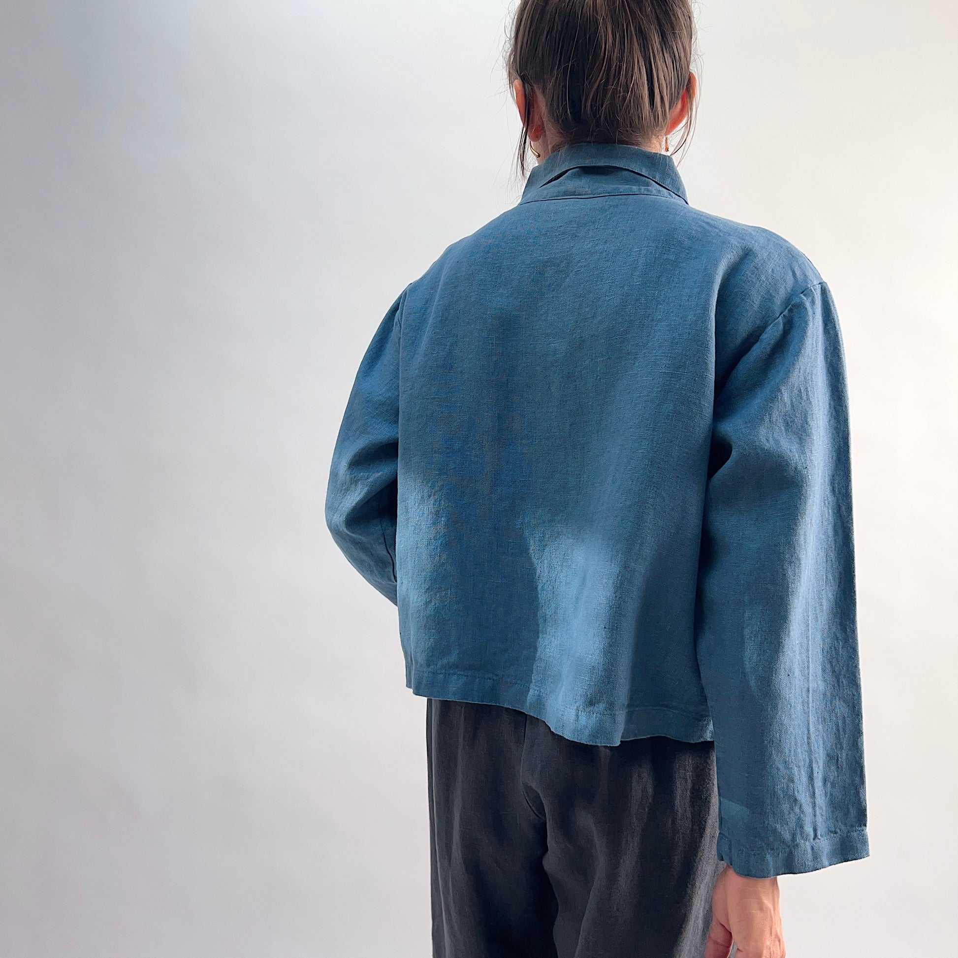 Back view of the Bryn Walker Heavy Linen Audrey Jacket in Vitznau, showing cropped hemline, relaxed silhouette, and linen texture
