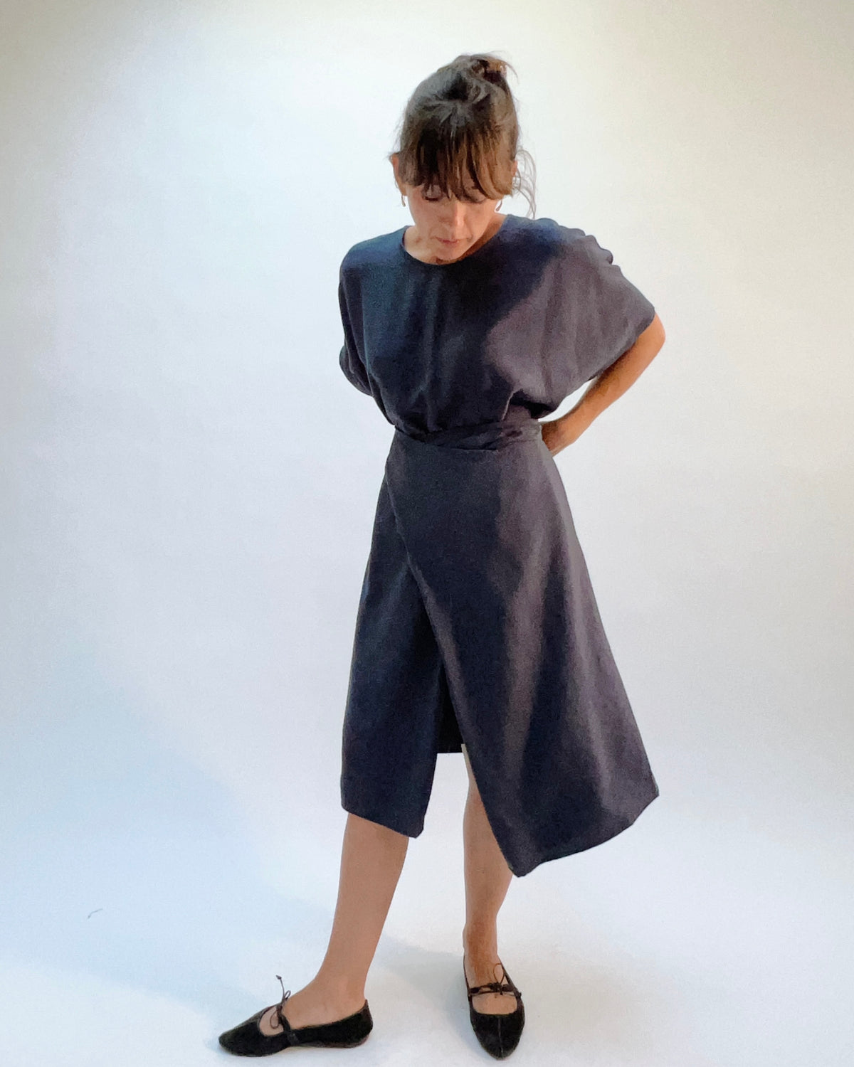 Niche Origami Dress in Carbon, front view showing the twisted styling with asymmetric hem in dark carbon lightweight rayon

