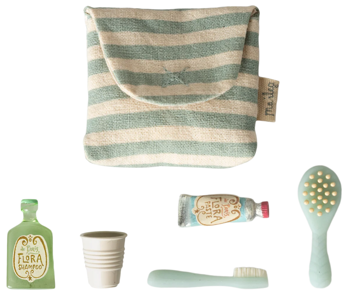 Maileg Toothbrush Set in Blue Striped Bag — flat lay of the blue and cream striped cotton toiletry bag with five miniature accessories: Flora Shampoo bottle, ribbed water cup, toothbrush, Flora Paste toothpaste tube, and hairbrush
