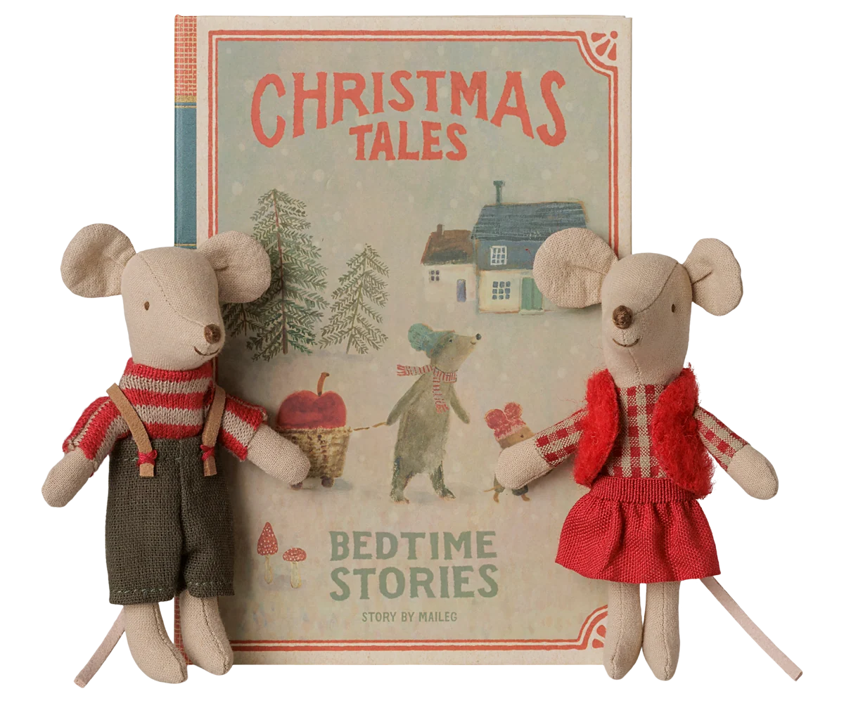 Maileg Christmas twin mice beside a closed Christmas Tales book box; Brother wears suspenders and Sister wears a red vest and skirt.
