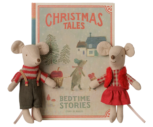 Maileg Christmas twin mice beside a closed Christmas Tales book box; Brother wears suspenders and Sister wears a red vest and skirt.
