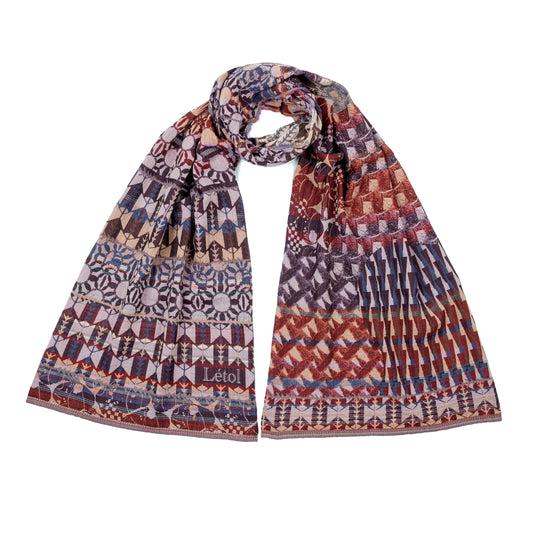 Létol Come Scarf in Cassis, looped and laid flat against a white background showing both sides simultaneously — one side featuring a bold geometric Art Deco pattern of repeating chevrons, medallions, and stylized floral rosettes in blackcurrant, violet, and mauve on a dusty rose ground with the woven Létol signature, the other showing a densely interlaced diagonal lattice and chevron pattern in russet, burgundy, and purple with khaki accents
