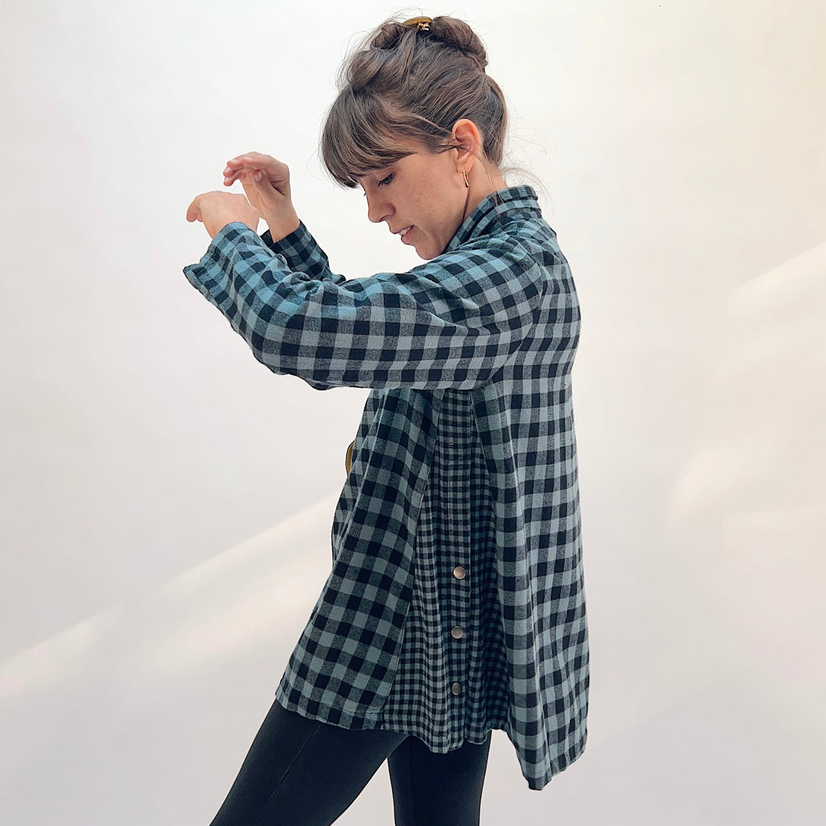 Eleven Stitch Placket Gusset Shirt in Dusty Denim, side profile view showing the high funnel collar, mustard contrast side gusset panel with snap buttons, and oversized silhouette in dusty blue and black gingham check
