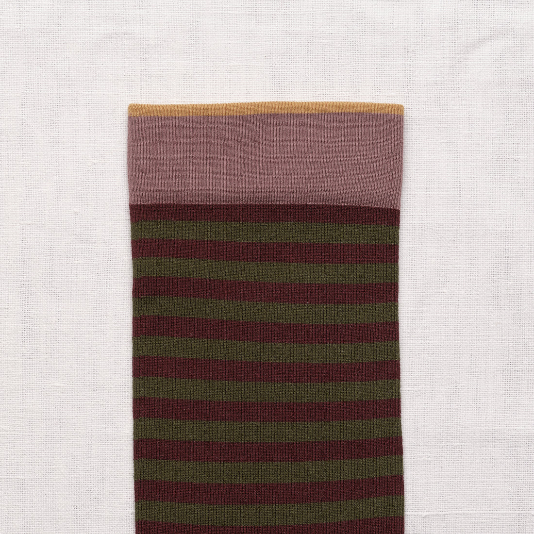 Bonne Maison Cypress Stripe Socks, close-up of the cuff showing the dusty pink cuff with thin mustard top stripe and cypress green and burgundy stripe body
