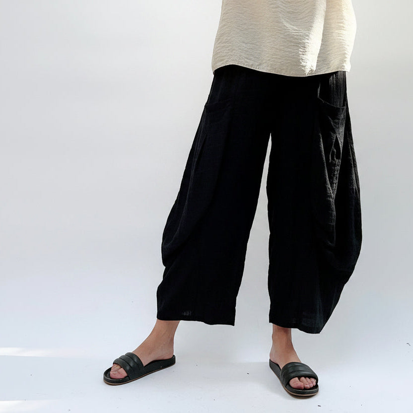 Person wearing plaid wide-leg pants and a beige top on a white background