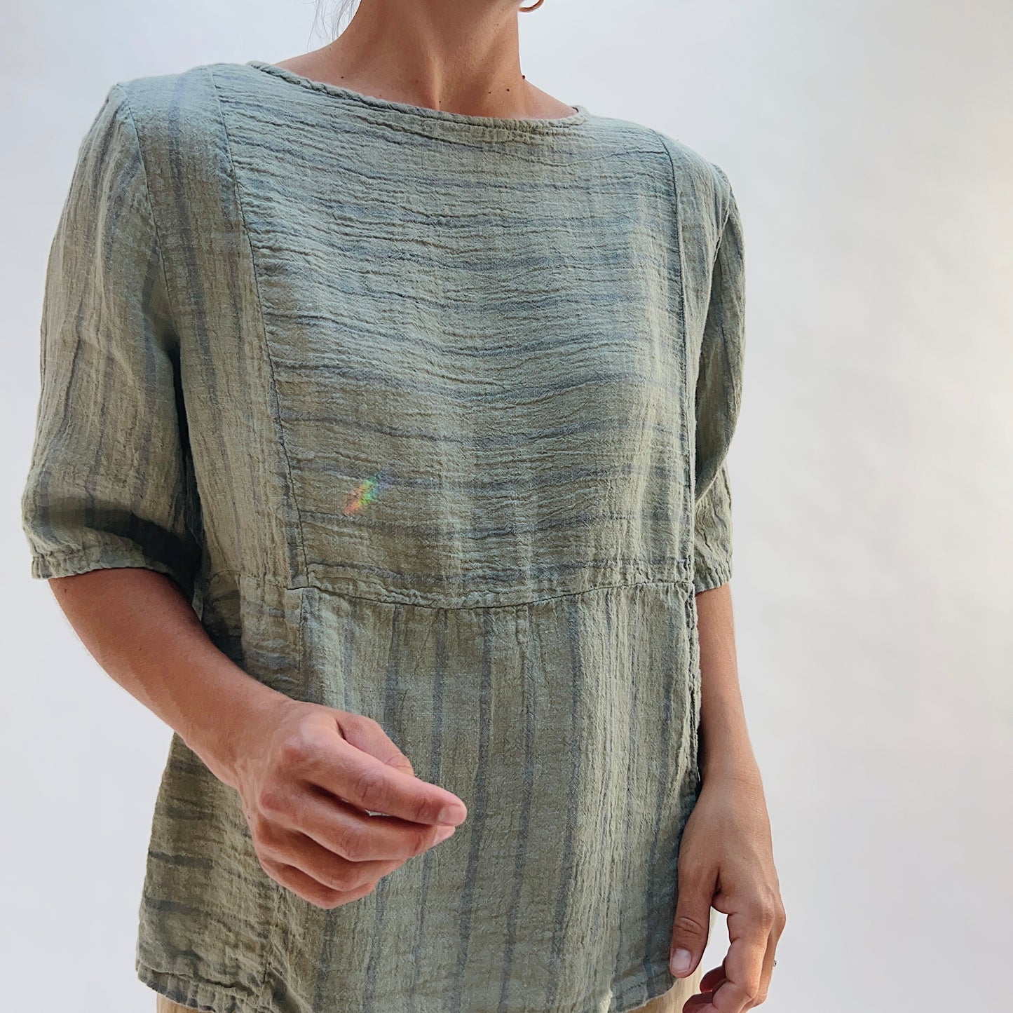 Model wearing the Seamed Boxy Striped Top in Balsam Green, a relaxed short-sleeve top with a textured stripe pattern, seamed waist detail