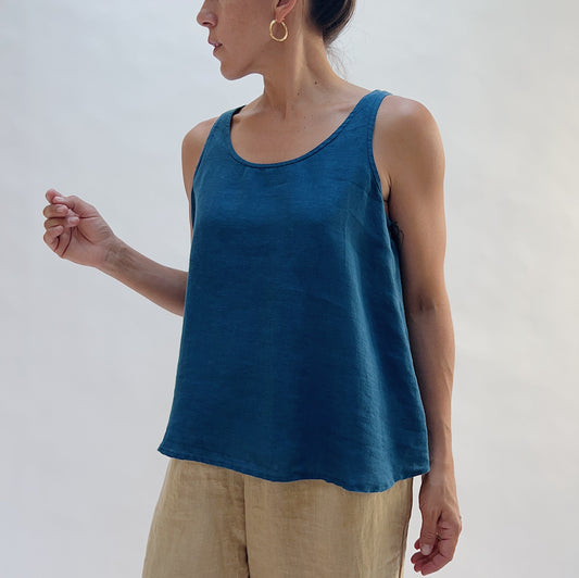 Front view of the Basic Tank in French Navy by Yuvita — a cropped 100% linen scoop-neck tank in deep teal blue, styled with tan linen trousers on a white background