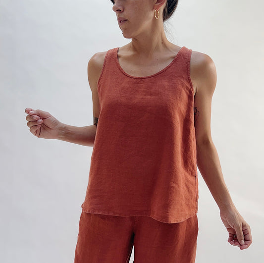 Close-up front view of the Basic Tank in Terracotta by Yuvita, showing the scoop neckline, wide straps, and relaxed linen drape in warm terracotta, styled with matching terracotta linen pants