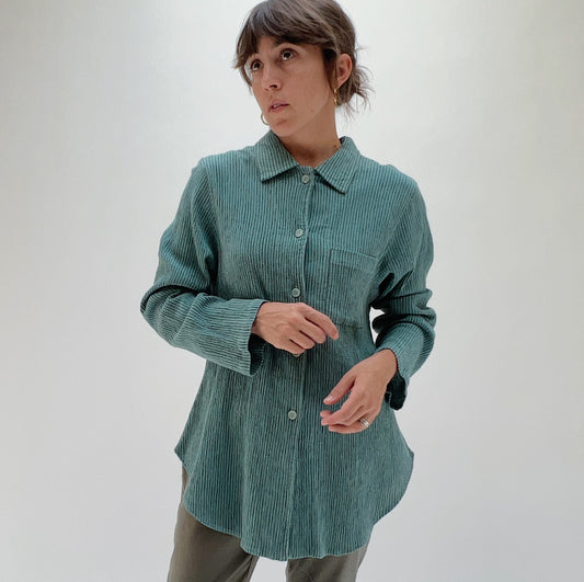 Front three-quarter view of model wearing Mill Valley Clothing Co blue sage boyfriend button-down shirt, showing point collar, chest pocket, and relaxed oversized fit