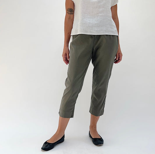Front view of model wearing Cut Loose kelp olive linen-Tencel taper crop pant, showing elastic waistband, tapered leg, side seam detail, and cropped length