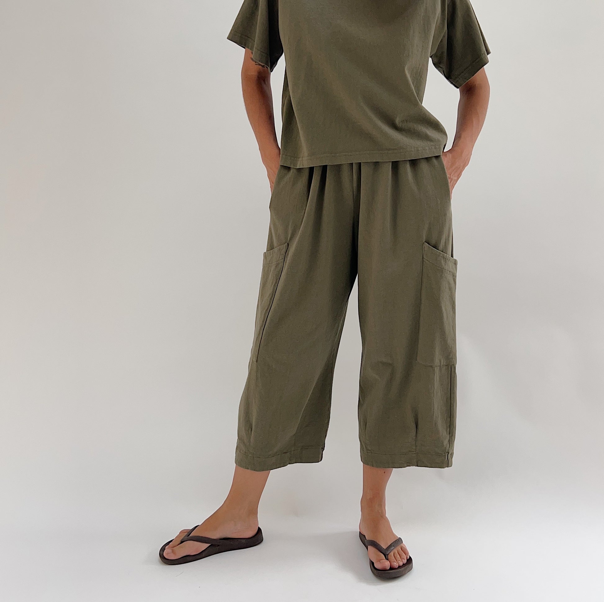 Front view of model wearing Bryn Walker jasper cotton Pasha pant, showing wide-leg silhouette, large patch pockets, elastic waist, and cropped capri length with banded hem
