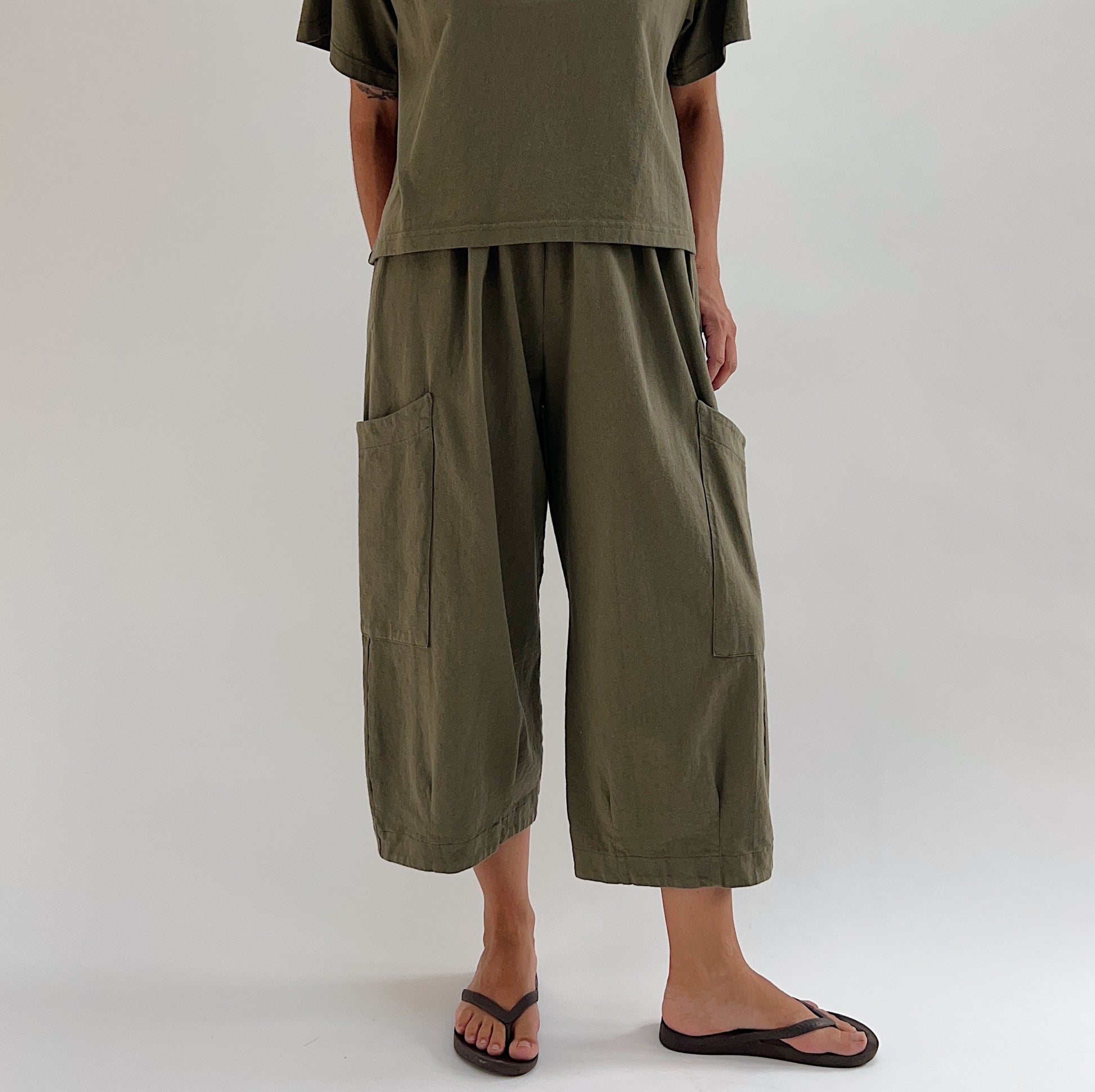Full front view of model wearing Bryn Walker jasper Pasha pant, showing both large patch pockets, relaxed wide-leg fit, elastic waist, and banded capri hem