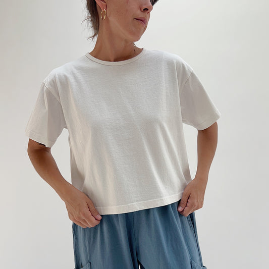 Full front view of model wearing Pacific Cotton cream crop crew tee, showing crew neckline, heavyweight cotton texture, boxy fit, and straight cropped hem