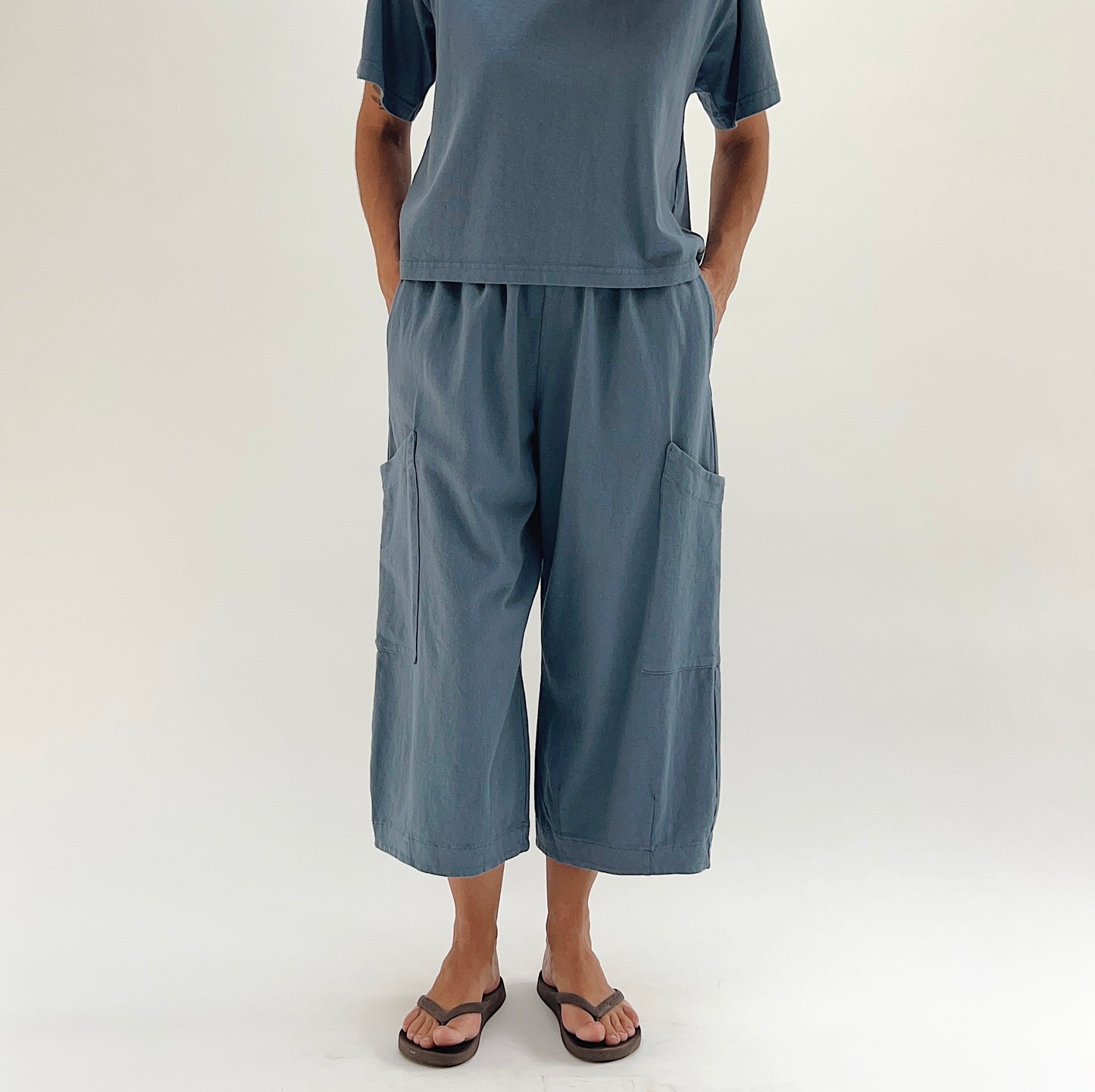 Full front view of model wearing Bryn Walker vitznau cotton Pasha pant, showing both large patch pockets, elastic waistband, wide cropped leg silhouette, and straight hem