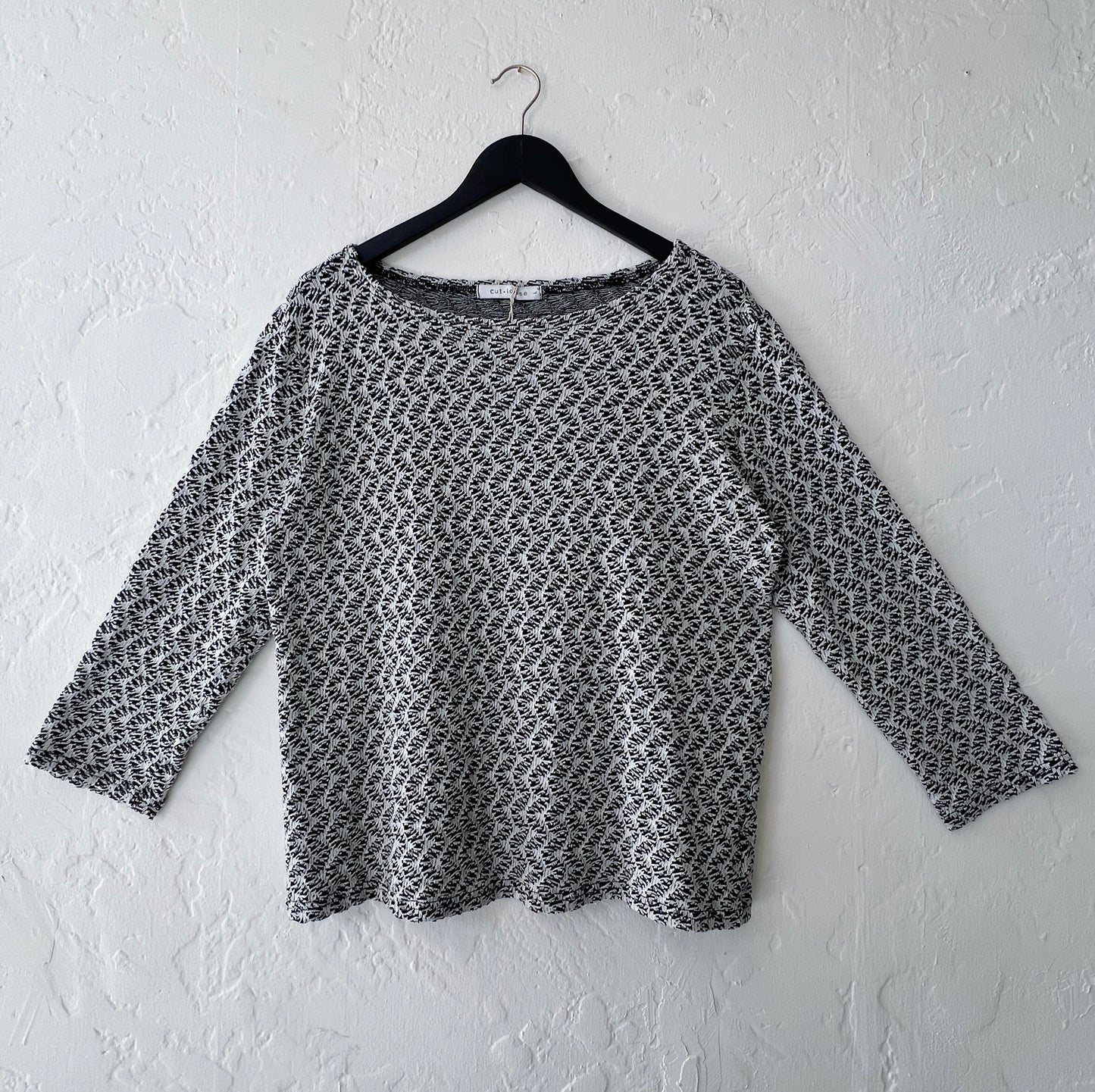 Cut Loose Wavy Crochet Knit 3/4 Sleeve Boatneck Top in Laundered, front view on hanger, black and white wavy diagonal crochet knit pattern with boatneck and 3/4 sleeves

