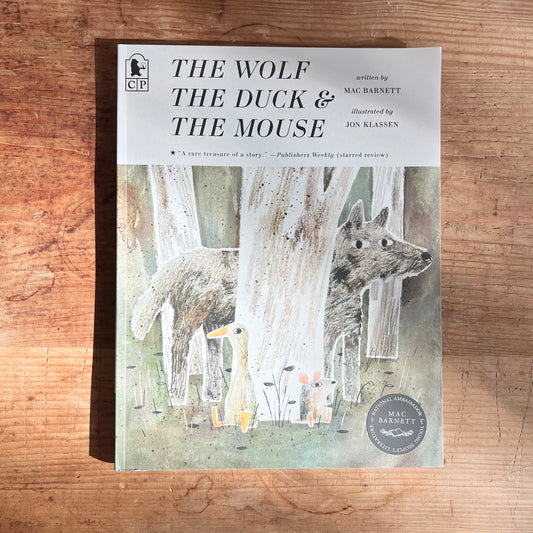 Paperback cover of The Wolf, the Duck, and the Mouse by Mac Barnett, illustrated by Jon Klassen, showing the three animals among pale tree trunks.
