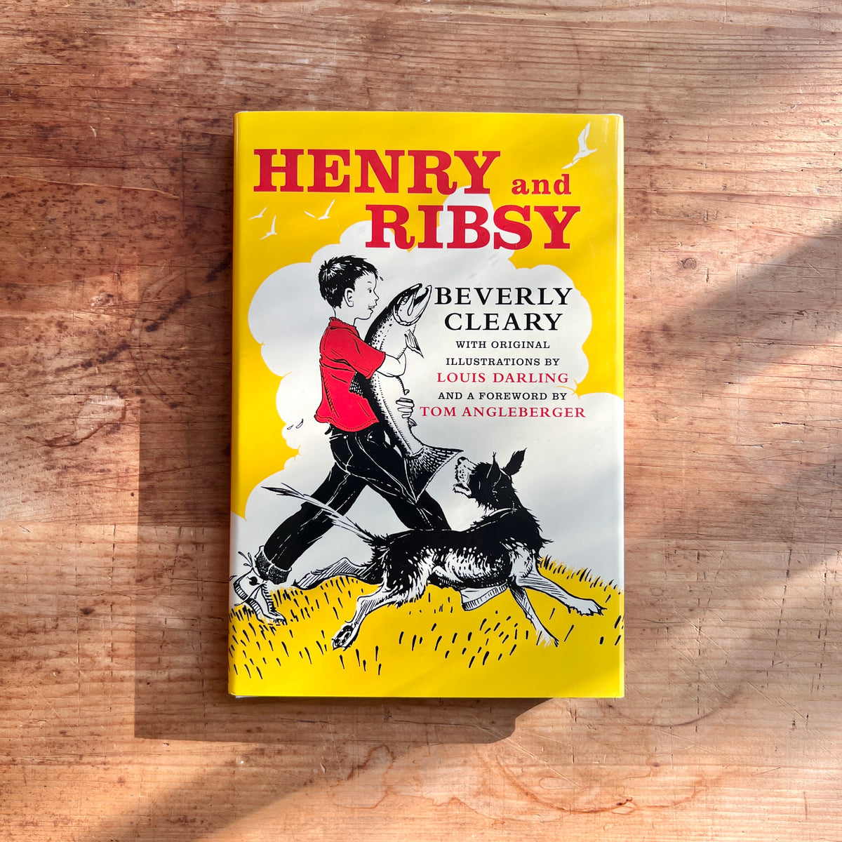 Yellow cover of Henry and Ribsy by Beverly Cleary, illustrated by Louis Darling, showing Henry carrying a large fish with Ribsy beside him.
