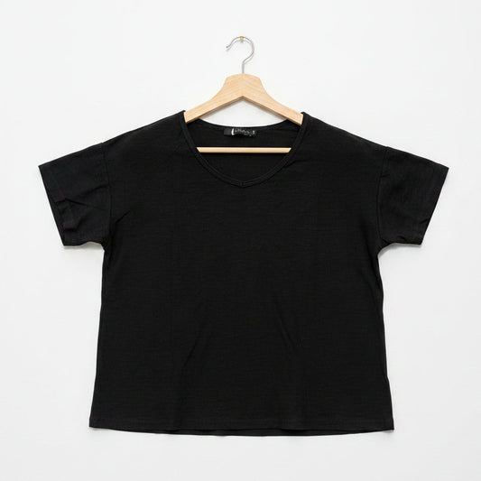 Black t-shirt on a wooden hanger against a white background