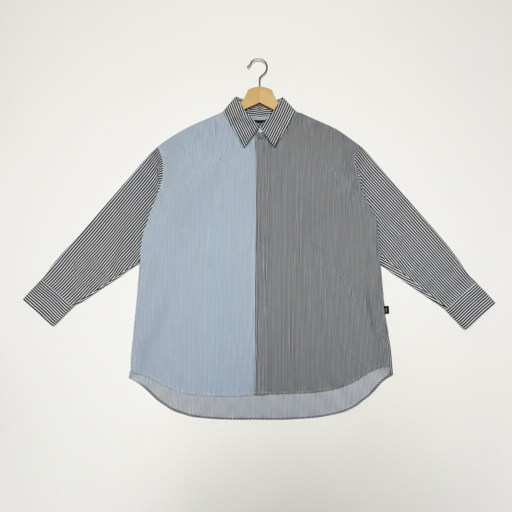Gray and blue striped shirt on a hanger against a white background