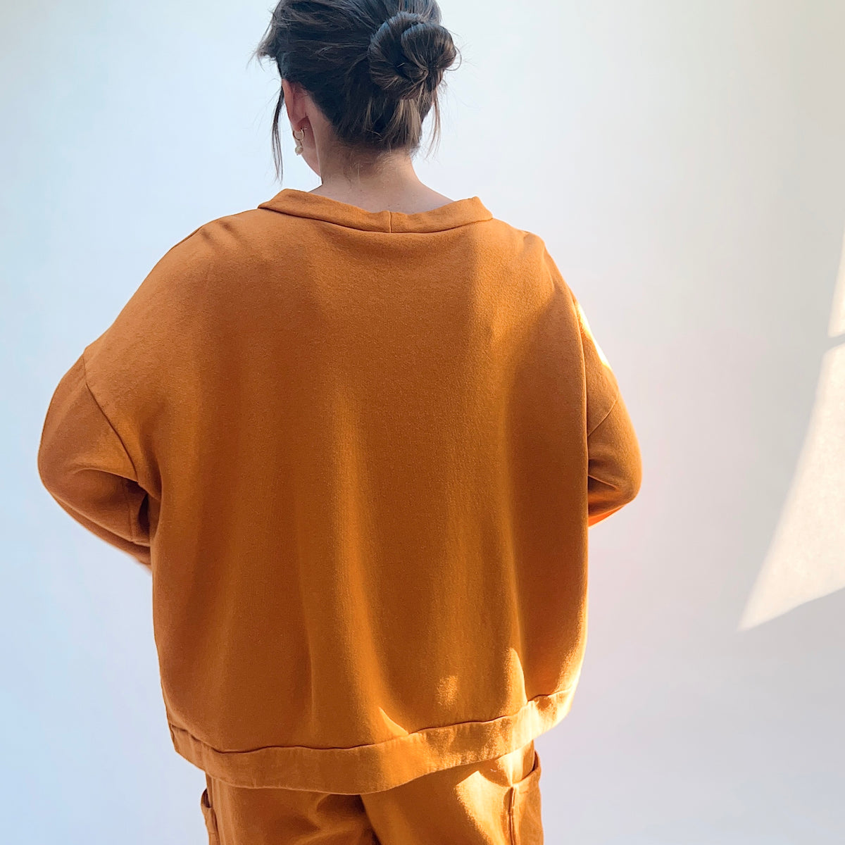 Back view of Alden Fleece Sweatshirt in Yera, showing the dropped shoulders, wide silhouette, and banded hem.
