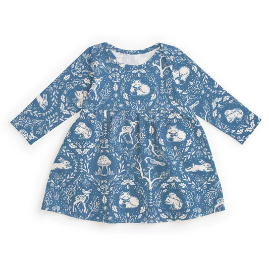A long-sleeve baby dress with a blue and white woodland animal print, featuring rabbits, deer, foxes, and mushrooms, laid flat on a white background.