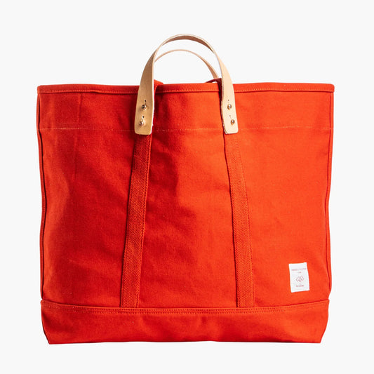 Immodest Cotton Large East West Tote in Persimmon red-orange canvas with natural leather handles.
