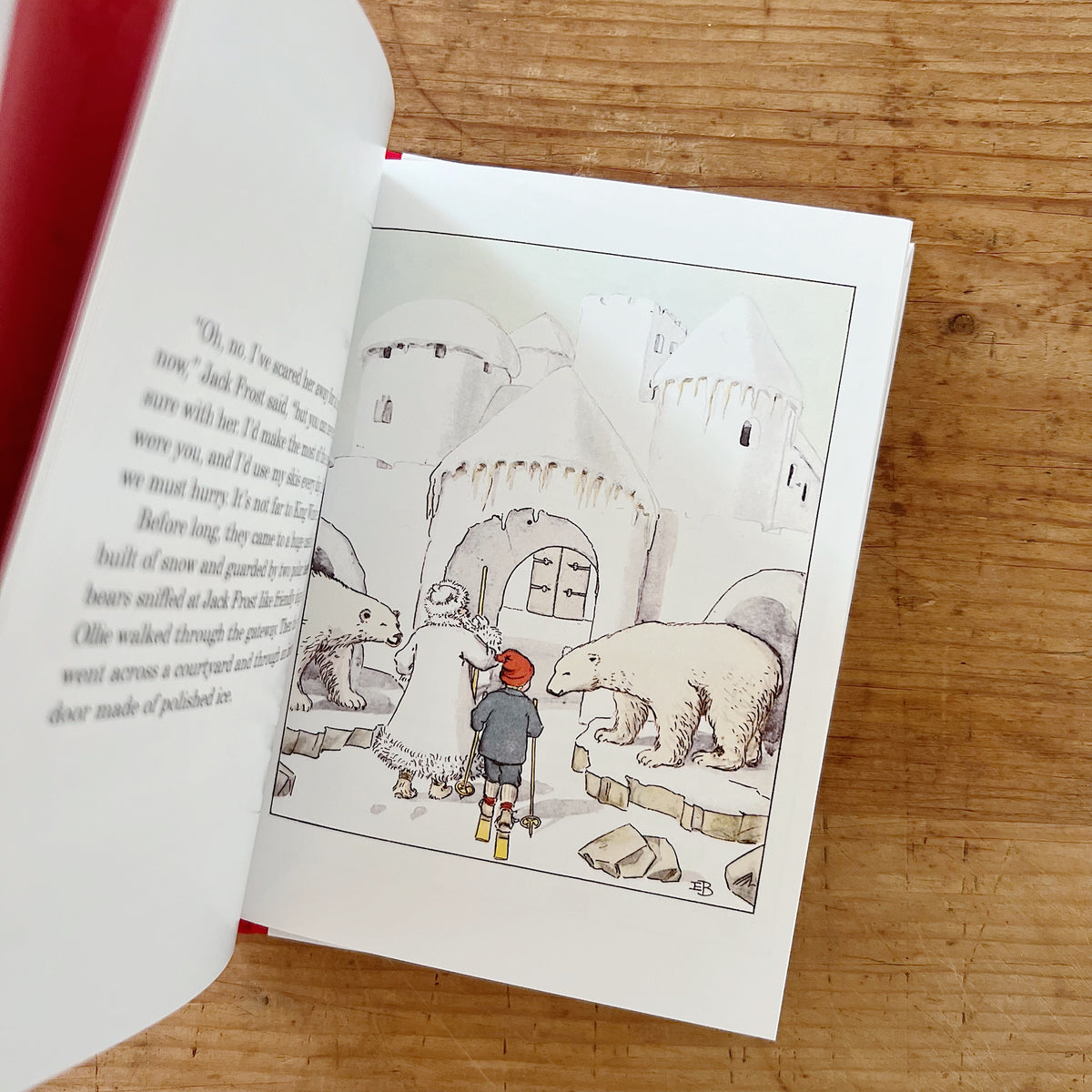 Interior illustration of Ollie on skis following Jack Frost toward a snow castle entrance flanked by two polar bears.
