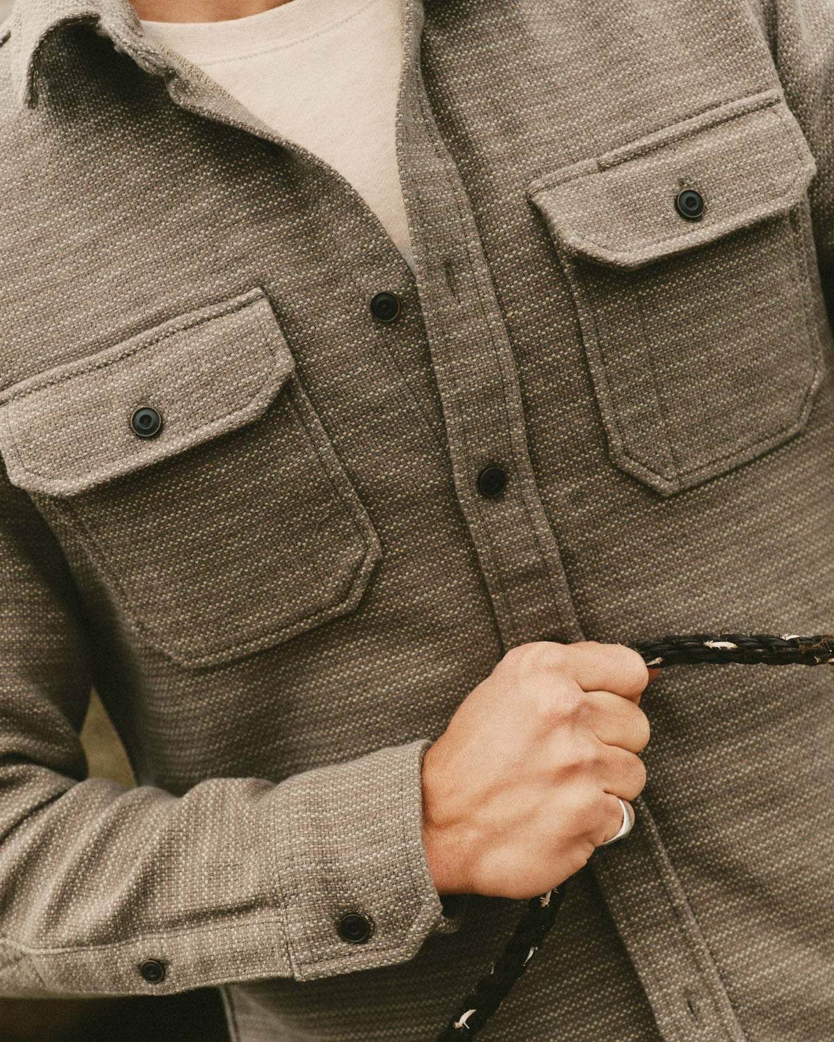 Close-up of the Division Shirt in Cypress on a model, showing sashiko texture, button-through chest pockets, and a buttoned cuff.
