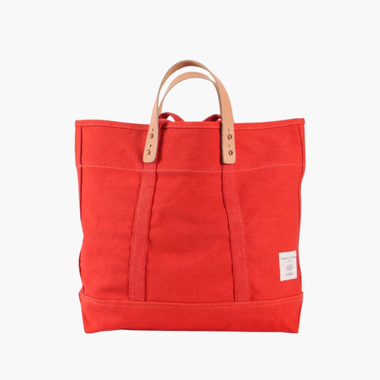 Immodest Cotton Small East West Tote in Persimmon red-orange canvas with natural leather handles.

