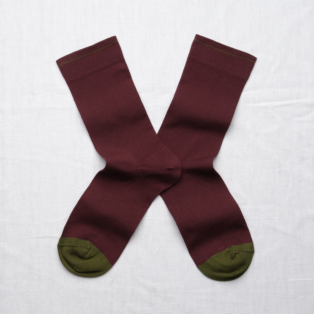 Bonne Maison Solid Burgundy Socks, flat lay pair showing solid burgundy body with contrast olive heel and toe
