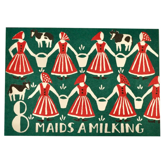 A square decorative sign or print featuring a folk-art style illustration of eight maid milkers in red and white striped dresses holding buckets, with two black-and-white cows and the text '8 MAIDS A MILKING' on a dark green background.