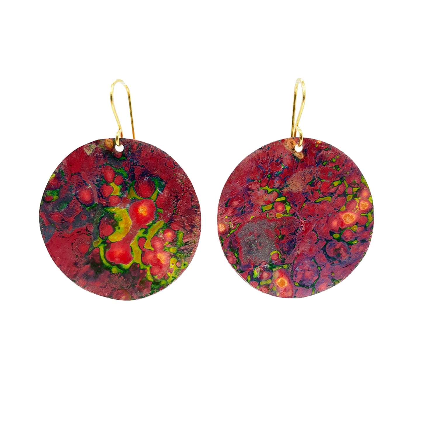 Pair of Sibilia Nature Earrings in Canyon, featuring large round treated brass disc drops with a vivid red, green, and orange multi-color oxide patina finish, hanging from gold wire hooks, on a white background
