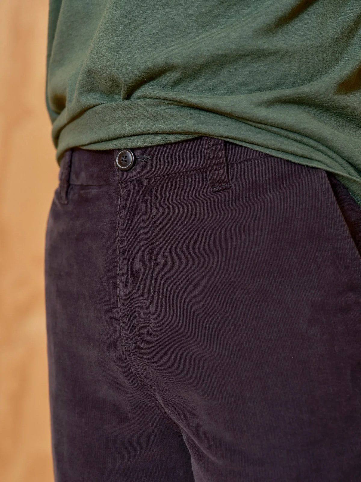 Close-up of the waistband and front pocket area of the Mollusk Boat Pants in Black Corduroy, showing the dark horn button, zip fly tab, front slash pocket opening, and fine micro-corduroy wale texture in deep black 100% cotton
