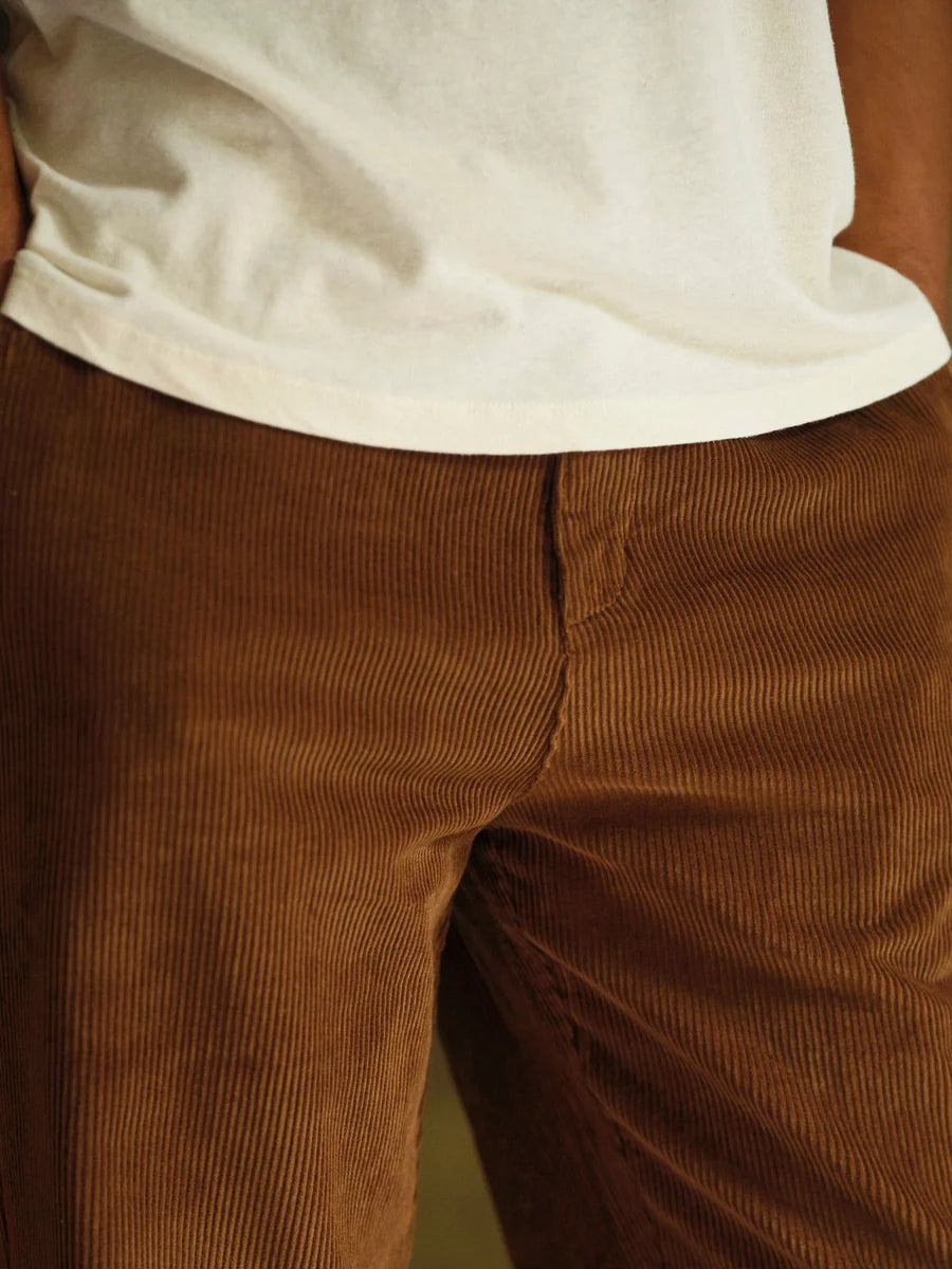 Close-up of the front waistband and fly area of the Mollusk Boat Pants in Brown Wide Wale Corduroy, showing the structured flat front panel, zip fly, and fine medium-wale corduroy texture in rich caramel brown
