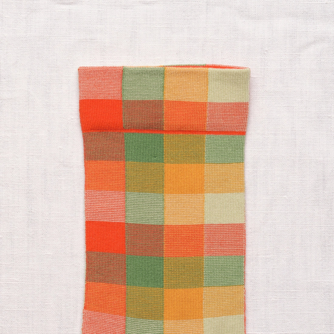 Bonne Maison Multicolor Plaid Socks, close-up of the cuff showing the multicolor plaid weave in orange, red, green, yellow, and cream
