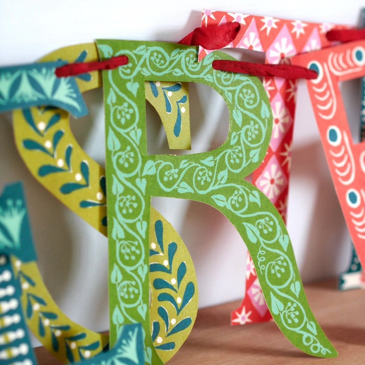 Decorative paper letters 'R' and 'S' with colorful patterns on a white background