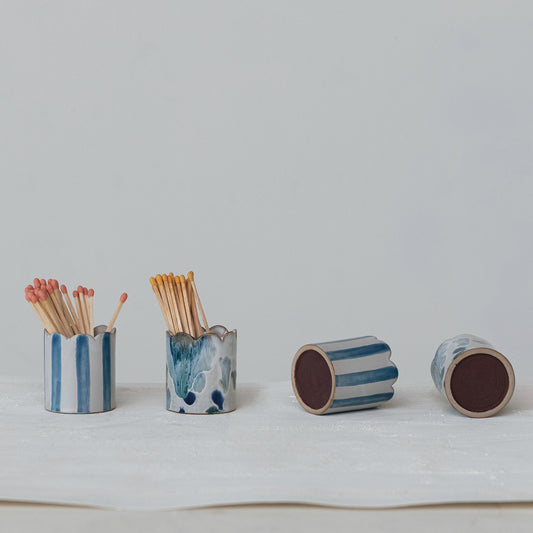 Set of ceramic match holders with matches on a light gray background