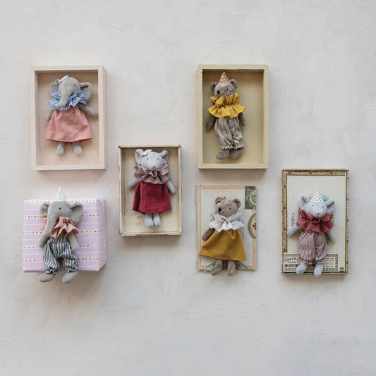 Small stuffed animals in decorative boxes on a wall