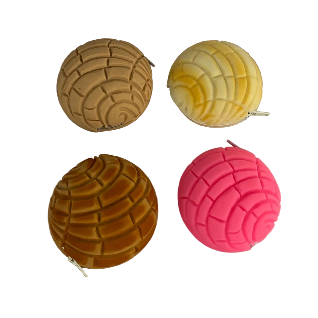 Four textured balls in gold, yellow, pink, and orange on a wooden surface.